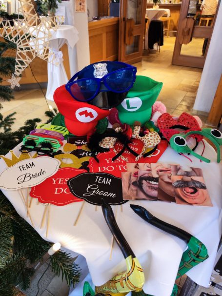 Vielfältige bunte Kostüm-Masken und Accessoires auf einem Tisch.