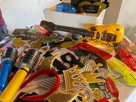 Bunte Party-Requisiten, darunter eine gelbe Gitarre und verschiedene Accessoires.