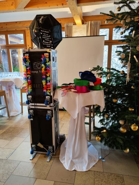 Ein Tisch mit Dekoration, Lautsprecher und Weihnachtsbaum im Hintergrund.