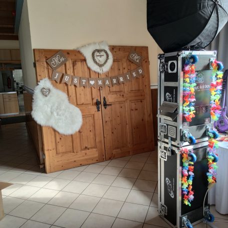 Holztüren mit Dekoration, daneben ein Fotobox-Ständer und ein großes, weißes Strumpf-Dekor.